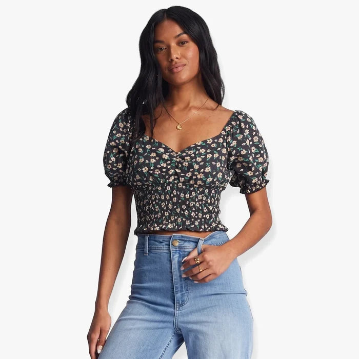 Billabong Womens Love Song black pebble puff sleeve top with a smocked bodice and floral print, worn by a model in a
