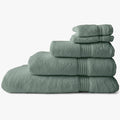 Stack of folded aqua marine Colibri Imperial Zerotwist bath towels, showing varying sizes.