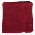Folded scarlet red Colibri Imperial Zerotwist Bath Sheet made from absorbent terry cloth material.