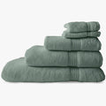 Stack of soft aqua marine Colibri Imperial Zerotwist bath towels, showing varying sizes and ribbed edges.