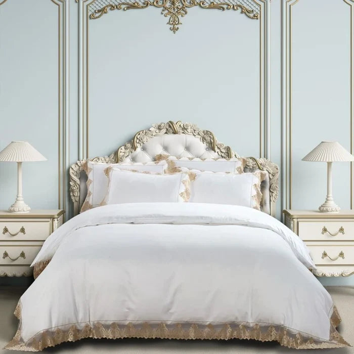 Cotton Co 400-thread-count embroidered queen duvet cover set in white with gold lace trim, shown on an ornate bed.