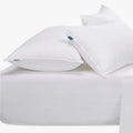 White Cotton Co 400 thread count King fitted sheet with two white pillows, showcasing soft fabric texture.
