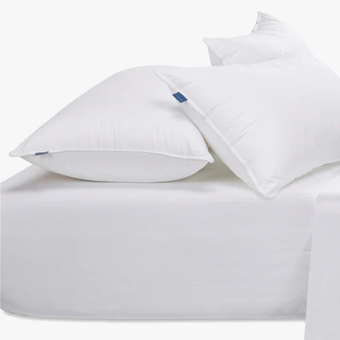 White Cotton Co 400 thread count King fitted sheet with two white pillows, showcasing soft fabric texture.