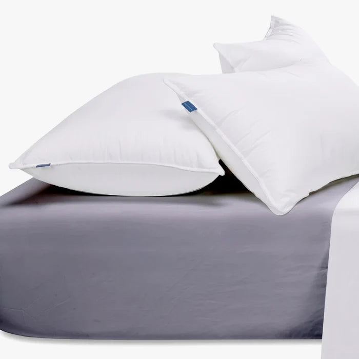 Two white pillows rest on a grey Cotton Co 400 Thread Queen fitted sheet, with a white flat sheet visible at the side.
