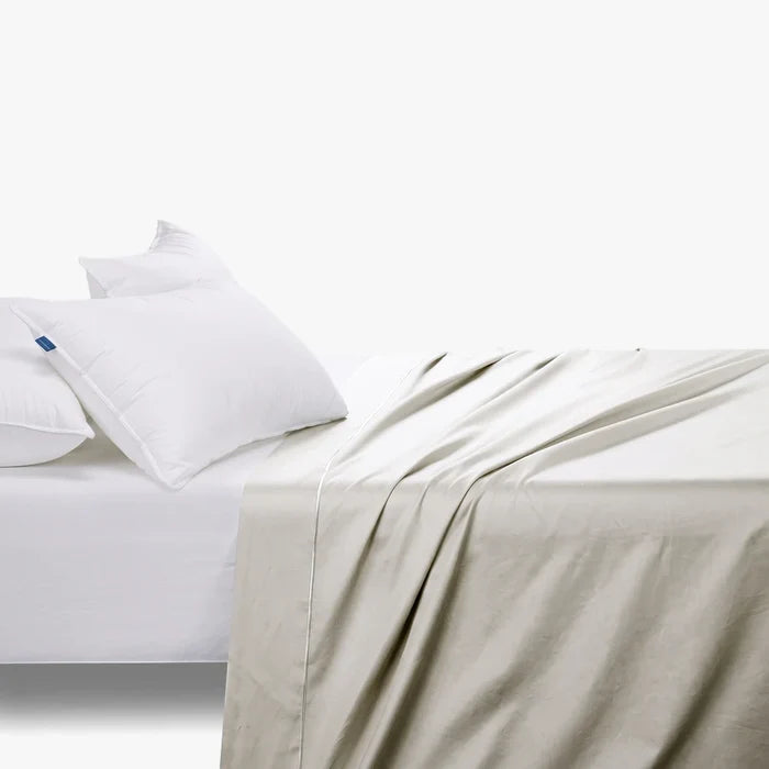 Cream Cotton Co 400 thread count Queen flat sheet draped over a bed with two white pillows.