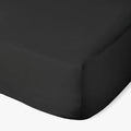 Black Cotton Co 400 thread count Super King fitted sheet, visible from a top-down angle, showing a neatly made corner.
