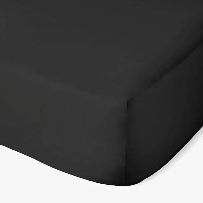Black Cotton Co 400 thread count Super King fitted sheet, visible from a top-down angle, showing a neatly made corner.