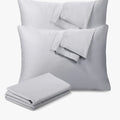 A pair of soft grey standard pillowcases from Cotton Co, neatly folded on top of each other and next to a matching grey