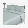 Duck egg blue cotton bedding set featuring a duvet cover and two pillowcases neatly arranged on a bed, shown with a bedside
