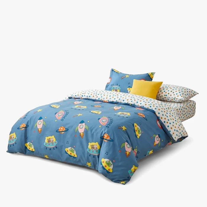 Cotton Co Kids Club Space Adventure duvet cover and pillowcase set, blue with rockets and UFOs, on a child's bed.