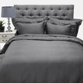 Grey cotton Oxford 400 thread count super king flat sheet displayed on a bed with a tufted headboard, nightstand, and lamp.