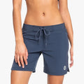 Roxy Ladies To Dye 7' Fixed Boardshort in mood indigo blue, worn on a model, front view, featuring a drawstring waist and