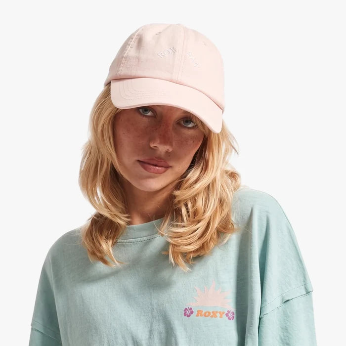 Roxy Women's Toadstool Baseball Cap in Pale Dogwood, worn by a blonde woman in a light blue t-shirt.