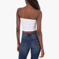 Sissy Boy Womens Mara Seamless Bandeau Top in white, worn by a model from the back, paired with blue denim jeans.