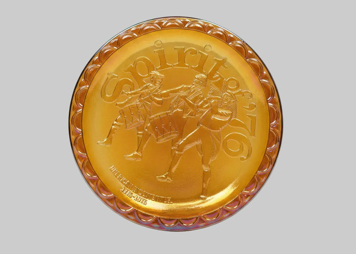 Gold-colored decorative plate with a horse and rider design on a white background