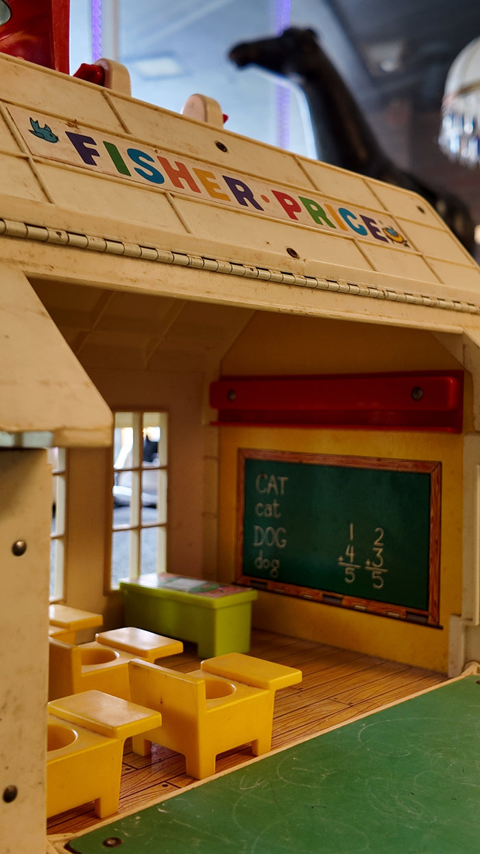 Vintage Fisher-Price toy with wooden structure, yellow chairs, and green chalkboard.