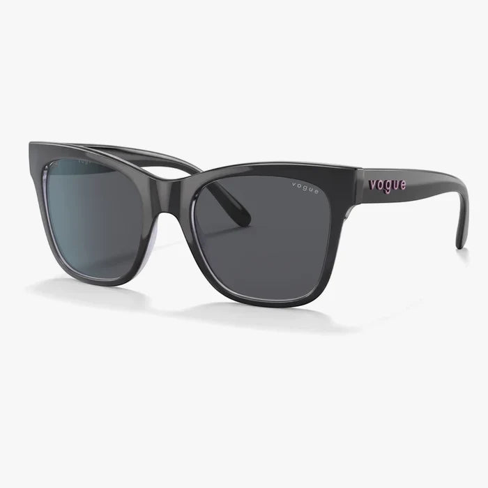 Dark grey Vogue ladies' sunglasses with dark lenses and a pink logo on the temple, presented at an angle.