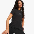 Puma Women's Ferrari Style short sleeve tee in black, worn by a woman with long curly hair, angled view.