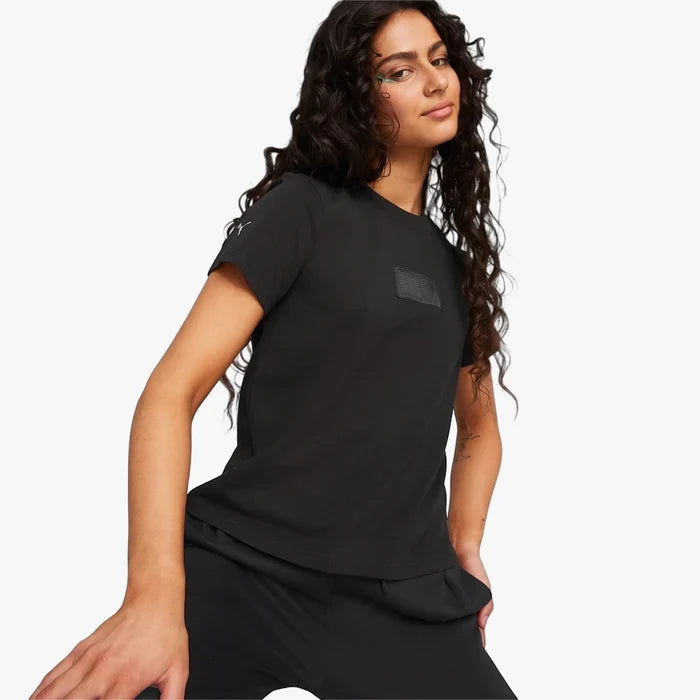 Puma Women's Ferrari Style short sleeve tee in black, worn by a woman with long curly hair, angled view.
